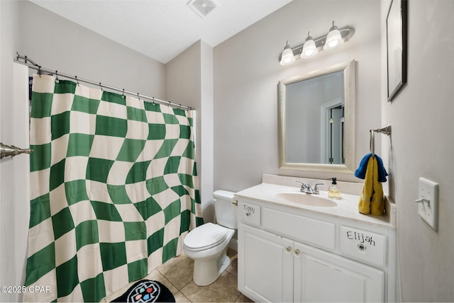 bathroom featuring toilet, a textured ceiling, vanity, curtained shower, and tile patterned flooring