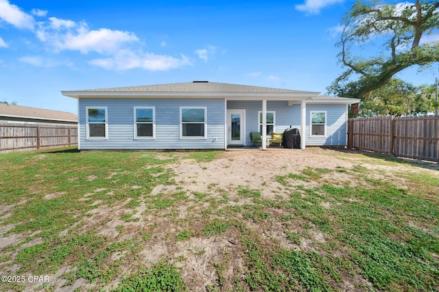 rear view of property featuring a yard