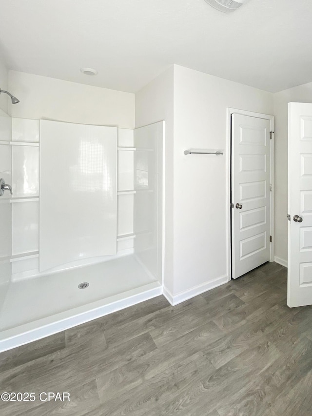 bathroom with hardwood / wood-style flooring and a shower