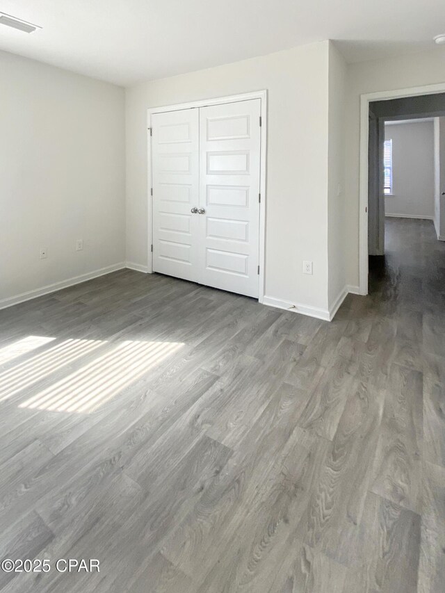 unfurnished bedroom with hardwood / wood-style flooring and a closet