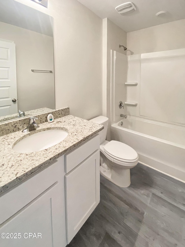 full bathroom featuring vanity, hardwood / wood-style floors, toilet, and shower / bath combination