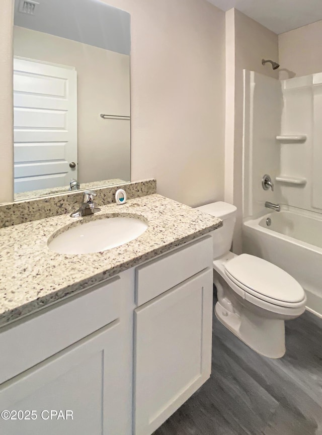 full bathroom featuring vanity, tub / shower combination, hardwood / wood-style floors, and toilet