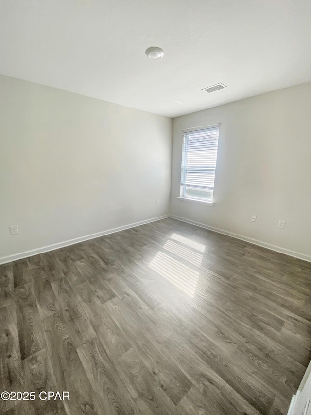 unfurnished room with dark wood-type flooring