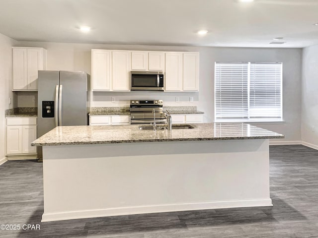 kitchen with sink, a center island with sink, appliances with stainless steel finishes, dark hardwood / wood-style flooring, and white cabinets