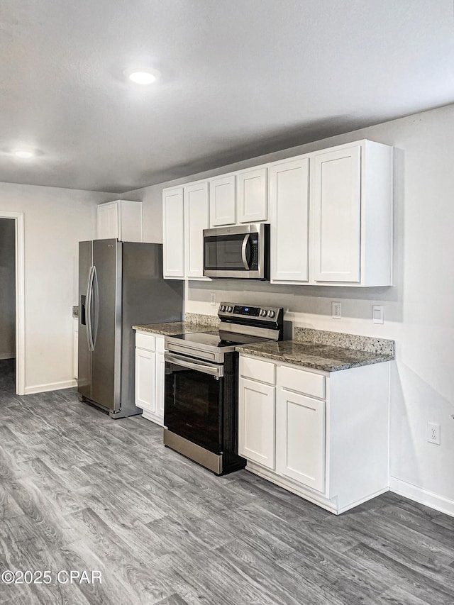 kitchen featuring white cabinetry, hardwood / wood-style floors, and appliances with stainless steel finishes