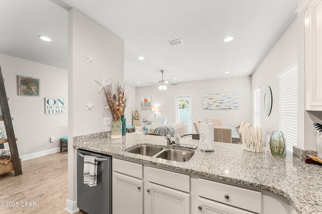 kitchen featuring sink, white cabinetry, light stone counters, light wood-type flooring, and stainless steel dishwasher