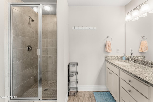 bathroom featuring vanity, hardwood / wood-style floors, and a shower with shower door