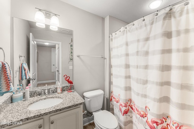 bathroom featuring vanity, toilet, and curtained shower