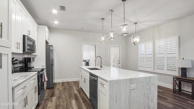 kitchen featuring sink, appliances with stainless steel finishes, white cabinets, a center island with sink, and decorative light fixtures