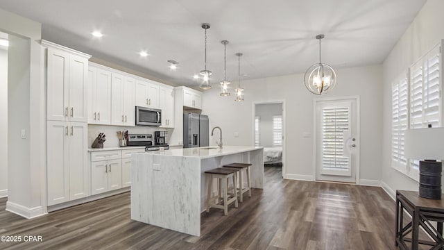 kitchen with white cabinetry, a center island with sink, and appliances with stainless steel finishes