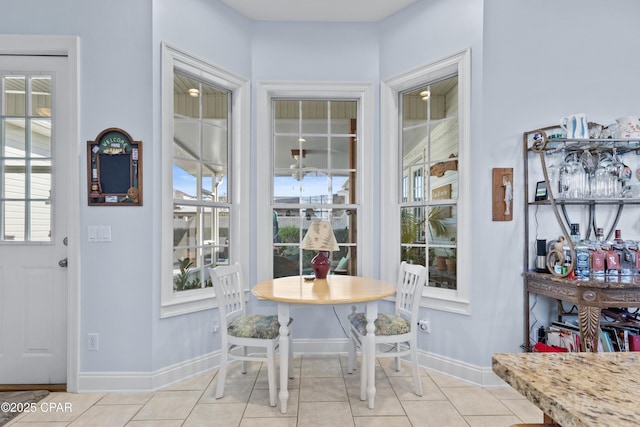 interior space featuring light tile patterned flooring and baseboards