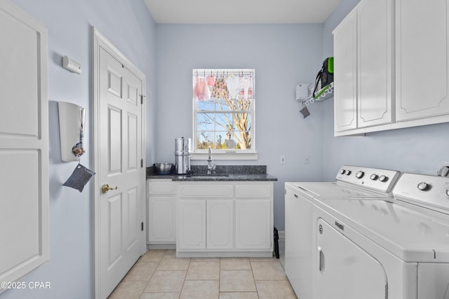 clothes washing area with light tile patterned floors, a sink, cabinet space, and washer and dryer