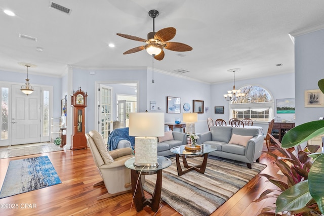 living room featuring ornamental molding, visible vents, and light wood finished floors