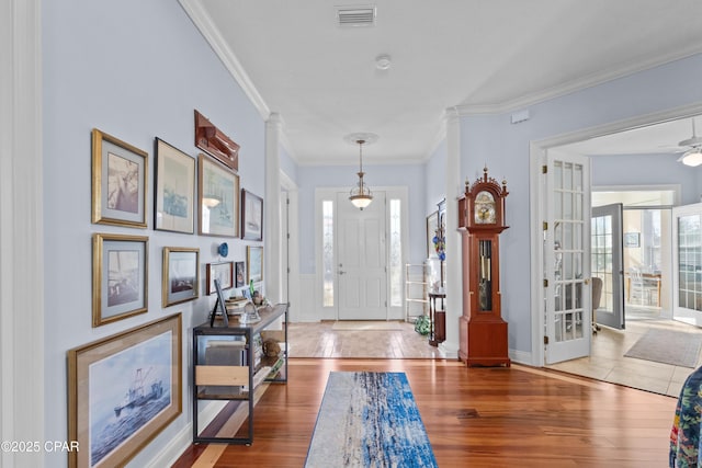 entryway featuring french doors, visible vents, light wood-style flooring, ornamental molding, and ceiling fan