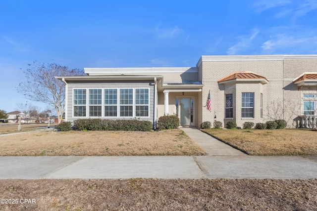 view of front of house featuring brick siding and a front yard