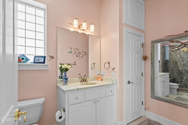 bathroom with baseboards, toilet, tile patterned floors, vanity, and a closet