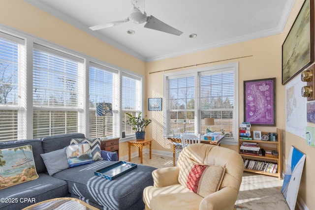 living area with ornamental molding, baseboards, and a ceiling fan