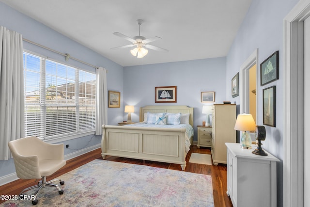 bedroom featuring ceiling fan, wood finished floors, and baseboards