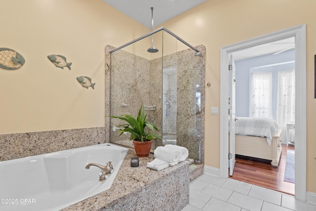 full bathroom featuring a stall shower, tile patterned flooring, a bath, and ensuite bathroom