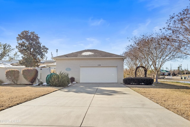 view of front of house featuring an attached garage, fence, concrete driveway, and brick siding