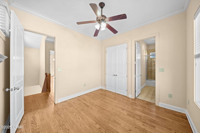 unfurnished bedroom featuring ensuite bath, ornamental molding, ceiling fan, light wood-type flooring, and a closet