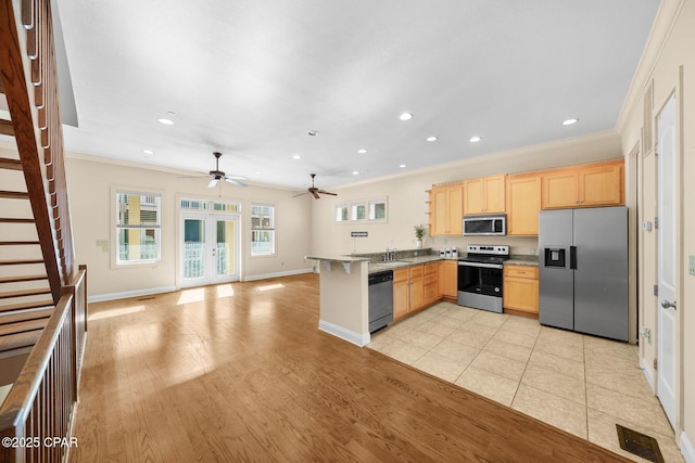 kitchen featuring crown molding, stainless steel appliances, kitchen peninsula, and light brown cabinets