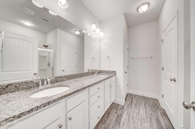 bathroom featuring vanity, wood-type flooring, and a shower