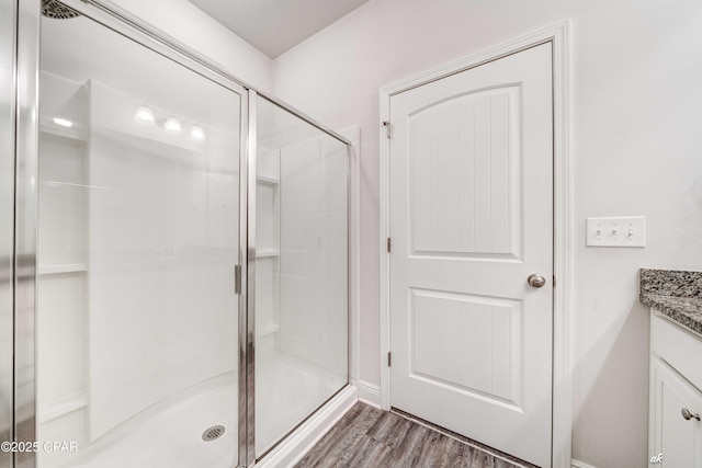 bathroom with vanity, wood-type flooring, and a shower with door