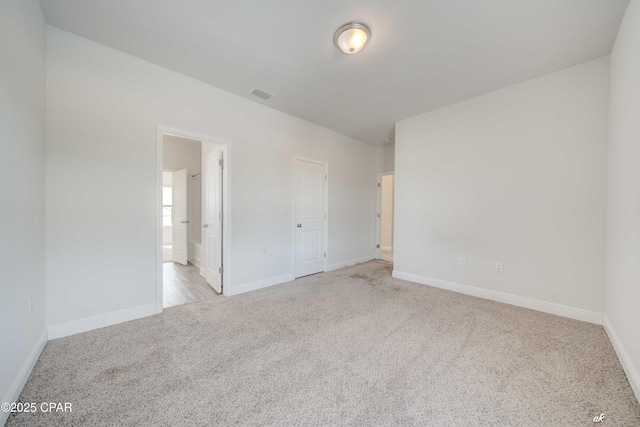 unfurnished bedroom with light colored carpet and a closet