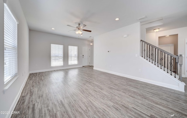 unfurnished living room with hardwood / wood-style floors, a wealth of natural light, and ceiling fan