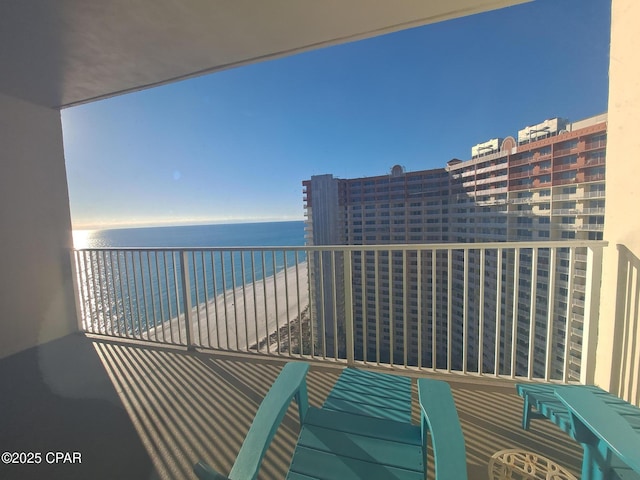 balcony featuring a beach view and a water view