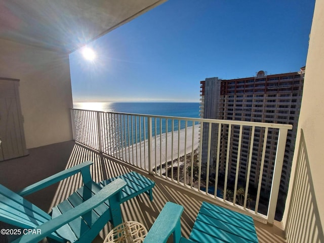 balcony featuring a water view and a beach view