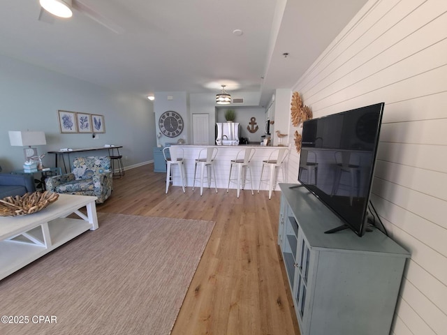 living room featuring wooden walls and light hardwood / wood-style floors