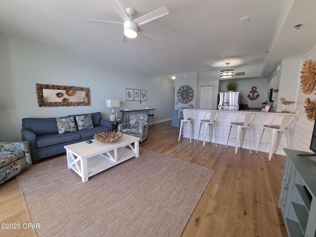 living room with ceiling fan and light hardwood / wood-style flooring