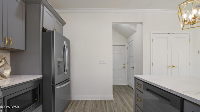 kitchen with pendant lighting, light hardwood / wood-style flooring, appliances with stainless steel finishes, gray cabinetry, and tasteful backsplash