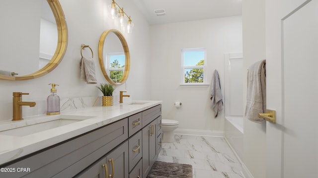 bathroom featuring vanity, a bathing tub, and toilet