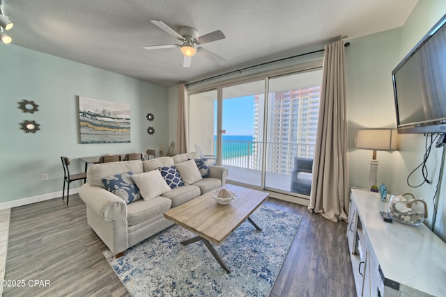 9900 S Thomas Dr Unit 1323, Panama City Beach, FL 32408 - living room featuring a ceiling fan, wood finished floors, and a textured ceiling