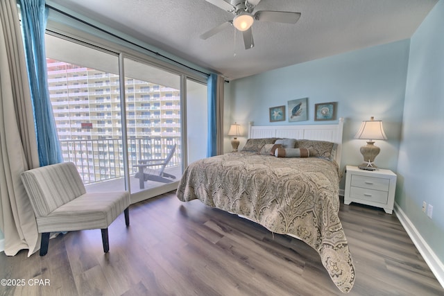 bedroom featuring multiple windows, dark hardwood / wood-style flooring, access to outside, and ceiling fan