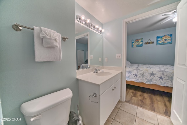 bathroom featuring tile patterned flooring, vanity, toilet, and ceiling fan