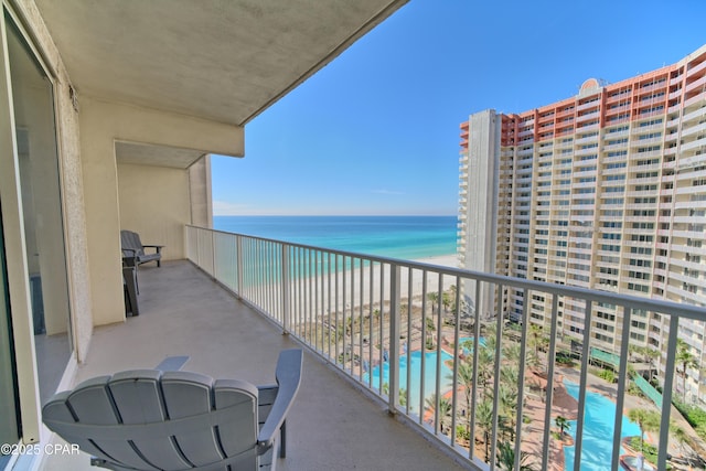 balcony featuring a water view and a beach view