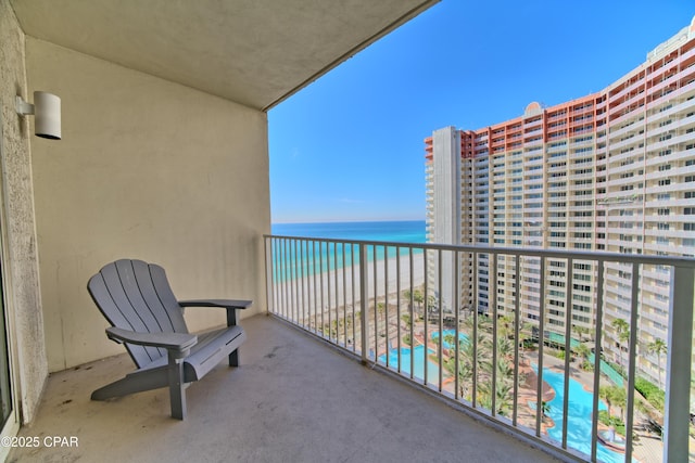 balcony featuring a water view and a beach view