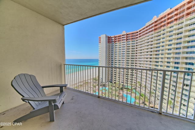 balcony featuring a water view and a beach view