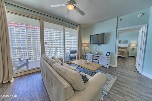 living room with a baseboard radiator, plenty of natural light, dark wood-type flooring, and a textured ceiling