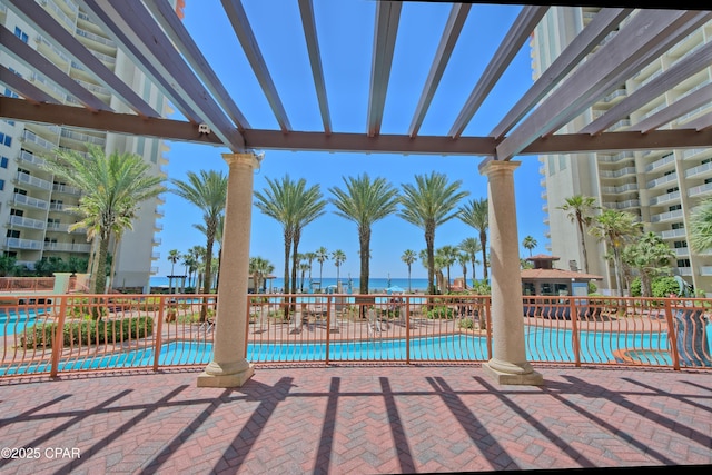 view of swimming pool with a pergola, a patio, and a water view