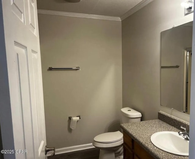 bathroom with vanity, ornamental molding, and toilet