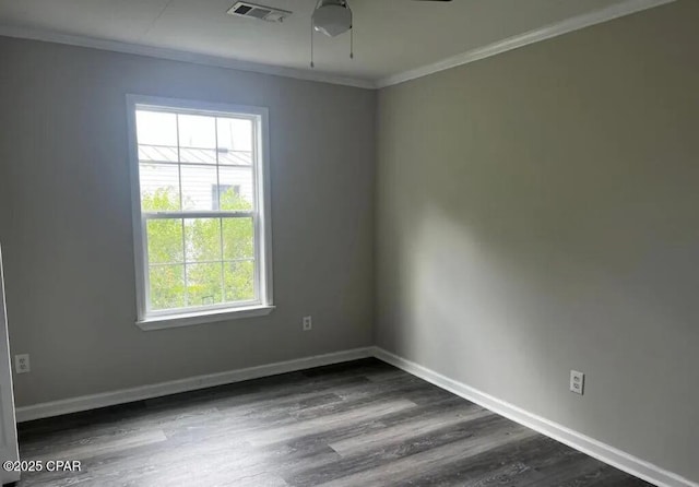 spare room featuring crown molding, dark hardwood / wood-style floors, and a wealth of natural light