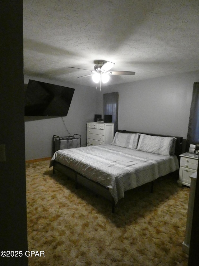 bedroom with ceiling fan, carpet floors, and a textured ceiling