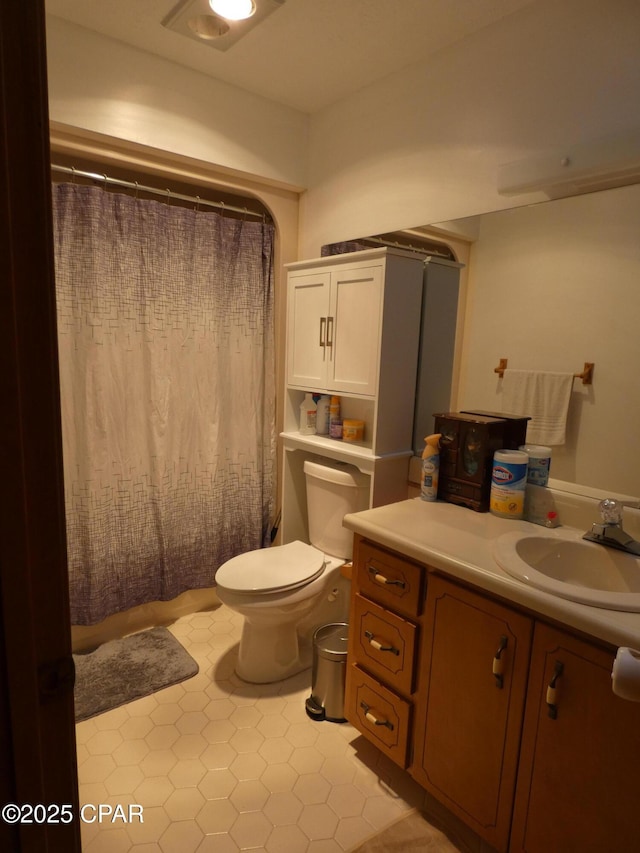 bathroom featuring a shower with curtain, vanity, and toilet