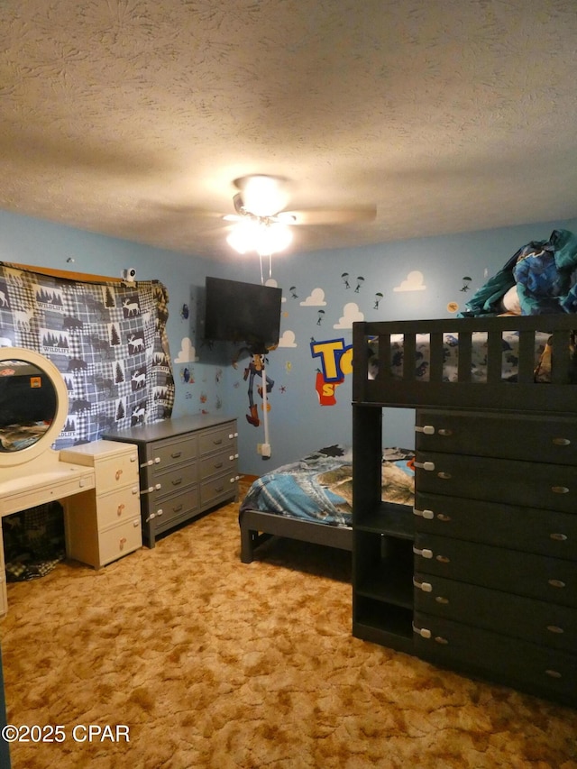 bedroom with ceiling fan, light colored carpet, and a textured ceiling