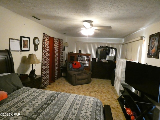 bedroom with ceiling fan and a textured ceiling